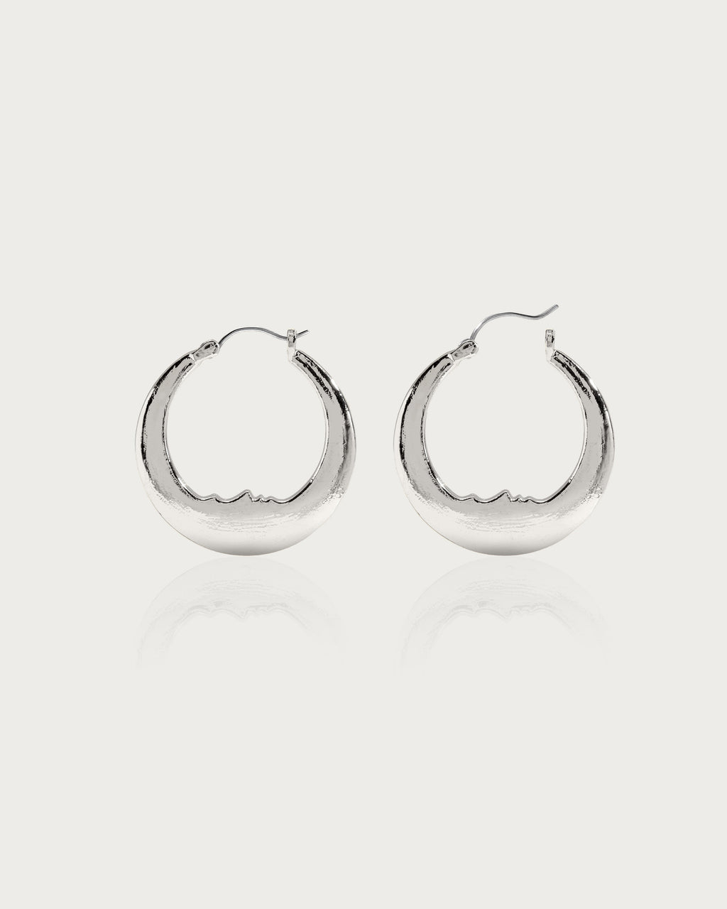 Silver Luna crescent moon hoop earrings with carved face, rhodium-plated brass, hypoallergenic post.