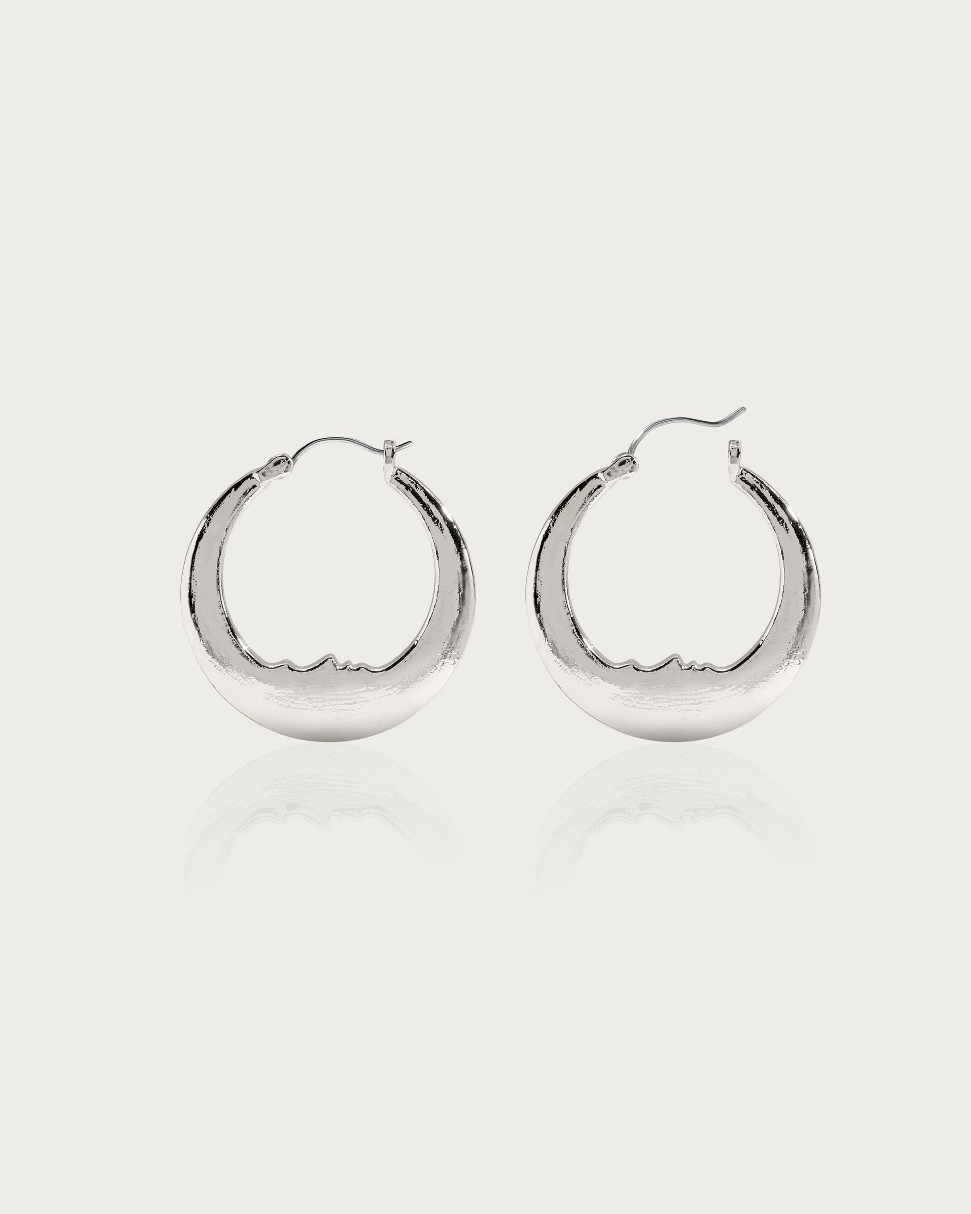 Silver Luna crescent moon hoop earrings with carved face, rhodium-plated brass, hypoallergenic post.